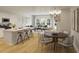 Open-concept floor plan connects a kitchen with a large island and a dining/living room with large sunny windows at 605 Red Monarch Way, Moncks Corner, SC 29461