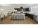 Well-lit kitchen with dark cabinets, stainless steel appliances, and center island at 612 Mclernon Trce, Johns Island, SC 29455