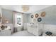 Charming Bedroom with elegant wallpaper, a cozy crib, and a decorative chandelier with a window providing natural light at 615 Red Monarch Way, Moncks Corner, SC 29461