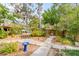 Serene backyard with mature trees, garden walkways, and a wooden deck with a slide at 619 E Erie Ave, Folly Beach, SC 29439