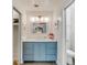 Well-lit bathroom showcasing a blue vanity and a mirror with gold accents at 619 E Erie Ave, Folly Beach, SC 29439
