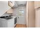 Clean laundry room with a washer, dryer, storage, and access to the backyard at 619 E Erie Ave, Folly Beach, SC 29439
