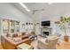 Bright living room featuring a cozy fireplace, skylights, hardwood floors, and comfortable seating at 619 E Erie Ave, Folly Beach, SC 29439