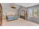 Bright primary bedroom with large window, guitar, and leaning ornate gold mirror at 619 E Erie Ave, Folly Beach, SC 29439