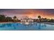 Community swimming pool and amenities illuminated at dusk, surrounded by palm trees and community buildings at 641 Cottage Landing Dr, Summerville, SC 29485