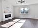 An empty living room has a ceiling fan, fireplace, hardwood floors and a window overlooking trees at 669 Silver Spruce St, Summerville, SC 29486