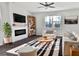 Bright living room with a ceiling fan, modern furniture, fireplace, and a large window at 669 Silver Spruce St, Summerville, SC 29486