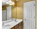 Bathroom featuring a double sink vanity, complemented by vintage gold wallpaper and a large mirror at 8715 Grassy Oak Trl, North Charleston, SC 29420