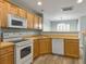 Bright kitchen features wood cabinets, white appliances, and durable countertops, perfect for cooking and entertaining at 8715 Grassy Oak Trl, North Charleston, SC 29420