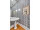 Powder room featuring pedestal sink and patterned wallpaper at 90 E Bay St, Charleston, SC 29401