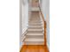 Carpeted staircase with wood handrail at 90 E Bay St, Charleston, SC 29401