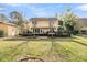 Large backyard with a manicured lawn, mature trees, and a deck perfect for relaxation and entertainment at 941 Law Ln, Mount Pleasant, SC 29464
