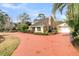 Charming home with a red circular driveway surrounded by lush landscaping and a quaint yellow facade at 941 Law Ln, Mount Pleasant, SC 29464