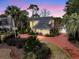 Stunning yellow two-story home with a red driveway and lush landscaping, creating a welcoming curb appeal at 941 Law Ln, Mount Pleasant, SC 29464