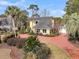 Stunning yellow two-story home with a red driveway and lush landscaping, creating a welcoming curb appeal at 941 Law Ln, Mount Pleasant, SC 29464