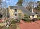 Quaint yellow home with a red brick driveway surrounded by natural landscaping at 941 Law Ln, Mount Pleasant, SC 29464
