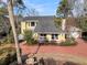 Charming yellow home with well-manicured landscaping, featuring a unique fountain and a red paved driveway at 941 Law Ln, Mount Pleasant, SC 29464