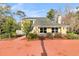 View of the front of the yellow home showing beautiful landscaping and a red concrete driveway at 941 Law Ln, Mount Pleasant, SC 29464