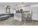 Open-concept kitchen and living area with modern appliances, bar seating, and cozy gray sectional at 941 Law Ln, Mount Pleasant, SC 29464