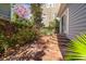 Charming backyard with brick patio, mature hedges, and a colorful tree at 100 Queen St, Charleston, SC 29401