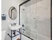 Modern bathroom with pedestal sink, black fixtures, and glass enclosed tiled shower at 100 Queen St, Charleston, SC 29401