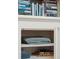Close up view of a bookcase with towels stored underneath at 100 Queen St, Charleston, SC 29401