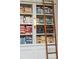 Floor to ceiling bookcase with rolling ladder, complete with books and a decorative lamp at 100 Queen St, Charleston, SC 29401