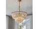 Elegant chandelier with hanging beads and candelabra lights, complemented by natural light at 100 Queen St, Charleston, SC 29401