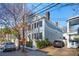 Lovely two-story home featuring classic architecture, mature trees, and a brick driveway at 100 Queen St, Charleston, SC 29401
