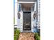 Inviting front door with decorative hardware, gas lanterns, and brick walkway at 100 Queen St, Charleston, SC 29401