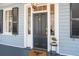 Close up of the front door with classic black door and gas lanterns and brick walkway at 100 Queen St, Charleston, SC 29401