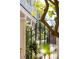 Elegant wrought iron gate leading to lush landscaping and a glimpse of the charming home at 100 Queen St, Charleston, SC 29401