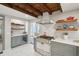 Spacious kitchen with wood beam ceiling, custom cabinets, gas range, wine cooler and marble floors at 100 Queen St, Charleston, SC 29401