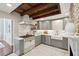 Custom kitchen with rustic wood beams, farmhouse sink, stainless steel appliances, and gas range at 100 Queen St, Charleston, SC 29401