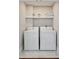 Efficient laundry area equipped with a washer, dryer, and storage shelf at 100 Queen St, Charleston, SC 29401
