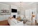 Bright living room featuring a decorative fireplace, white armchairs, hardwood floors, and elegant decor at 100 Queen St, Charleston, SC 29401