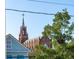 Picturesque view of a historic church steeple framed by lush greenery and a charming house at 100 Queen St, Charleston, SC 29401