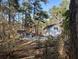 Backyard pool area featuring a pool house, lounge chairs, and surrounded by mature trees at 106 Caveson Dr, Summerville, SC 29483