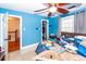 Blue bedroom with ceiling fan, window with gray curtains, and adjacent hallway at 106 Caveson Dr, Summerville, SC 29483