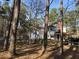 Charming two-story home featuring a red roof, white siding, and inviting porch with a rustic, wooded surrounding at 106 Caveson Dr, Summerville, SC 29483