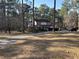 Inviting two-story home with a covered front porch, nestled among tall trees on a large lot at 106 Caveson Dr, Summerville, SC 29483
