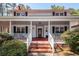 Close-up of a covered front porch with brick stairs, white railings, and black shutters at 106 Caveson Dr, Summerville, SC 29483
