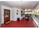 View of covered front porch with red painted wood flooring, white columns and a glass paneled front door at 106 Caveson Dr, Summerville, SC 29483