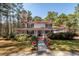 Inviting two-story traditional home with a wrap-around porch and colorful potted plants along the walkway at 106 Caveson Dr, Summerville, SC 29483