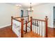 Wooden staircase with white railings and a chandelier, leading to the upper level at 106 Caveson Dr, Summerville, SC 29483