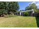 An expansive backyard, showing a patio, lawn, privacy fence and white trim of windows of sunroom at 108 Nightingale Manor, North Charleston, SC 29418