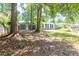 A backyard of a house, showing the lawn, scattered trees and white siding of the house at 108 Nightingale Manor, North Charleston, SC 29418