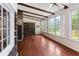 Bright sunroom with brick accents, hardwood floors, and lots of windows, perfect for a relaxing space at 108 Nightingale Manor, North Charleston, SC 29418