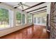 Bright sunroom features hardwood floors, ceiling fans, and large windows for ample natural light and backyard views at 108 Nightingale Manor, North Charleston, SC 29418