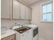 Laundry room boasts upper cabinets, modern washer and dryer, and natural light at 109 Forest Springs Rd, Moncks Corner, SC 29461